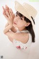 A woman in a straw hat is posing for a picture.